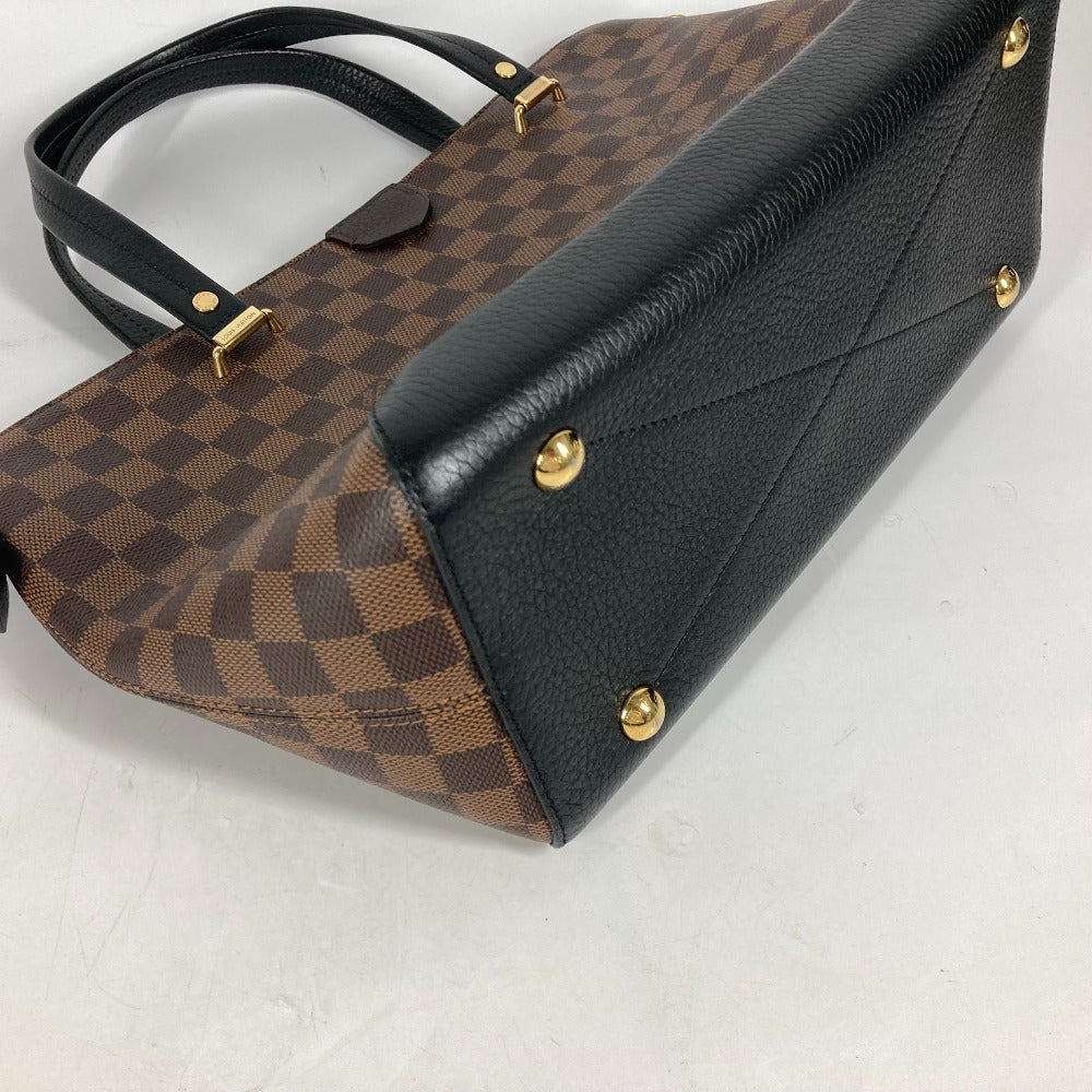 Designer handbag with brown checkered pattern and black leather accents on a light gray background