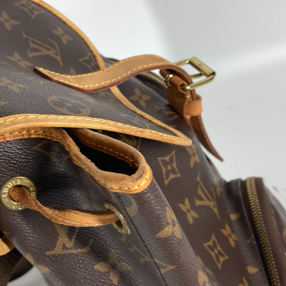 Close-up of a brown leather handbag with gold hardware and monogram pattern.