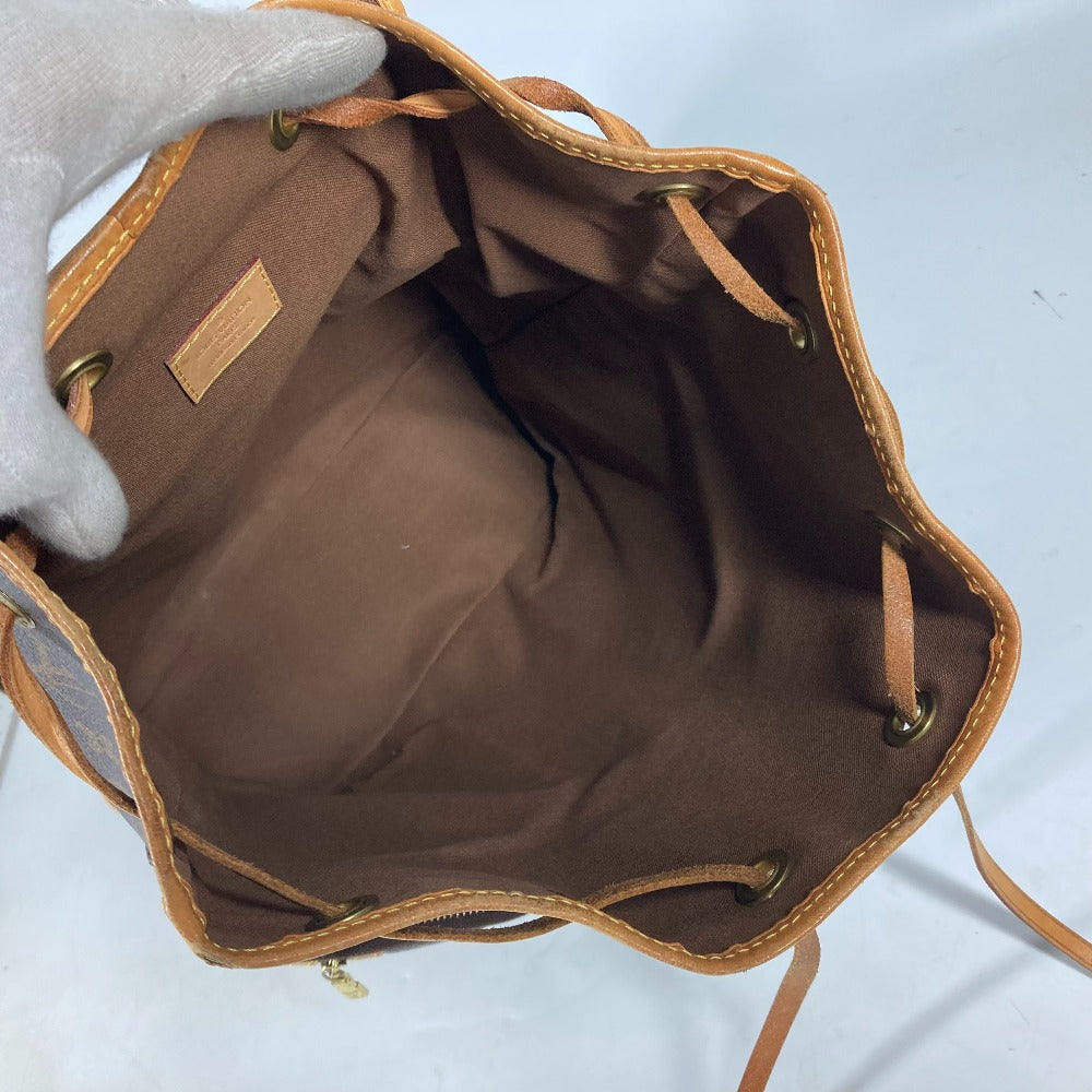 Brown leather bag with gold accents on a light gray background