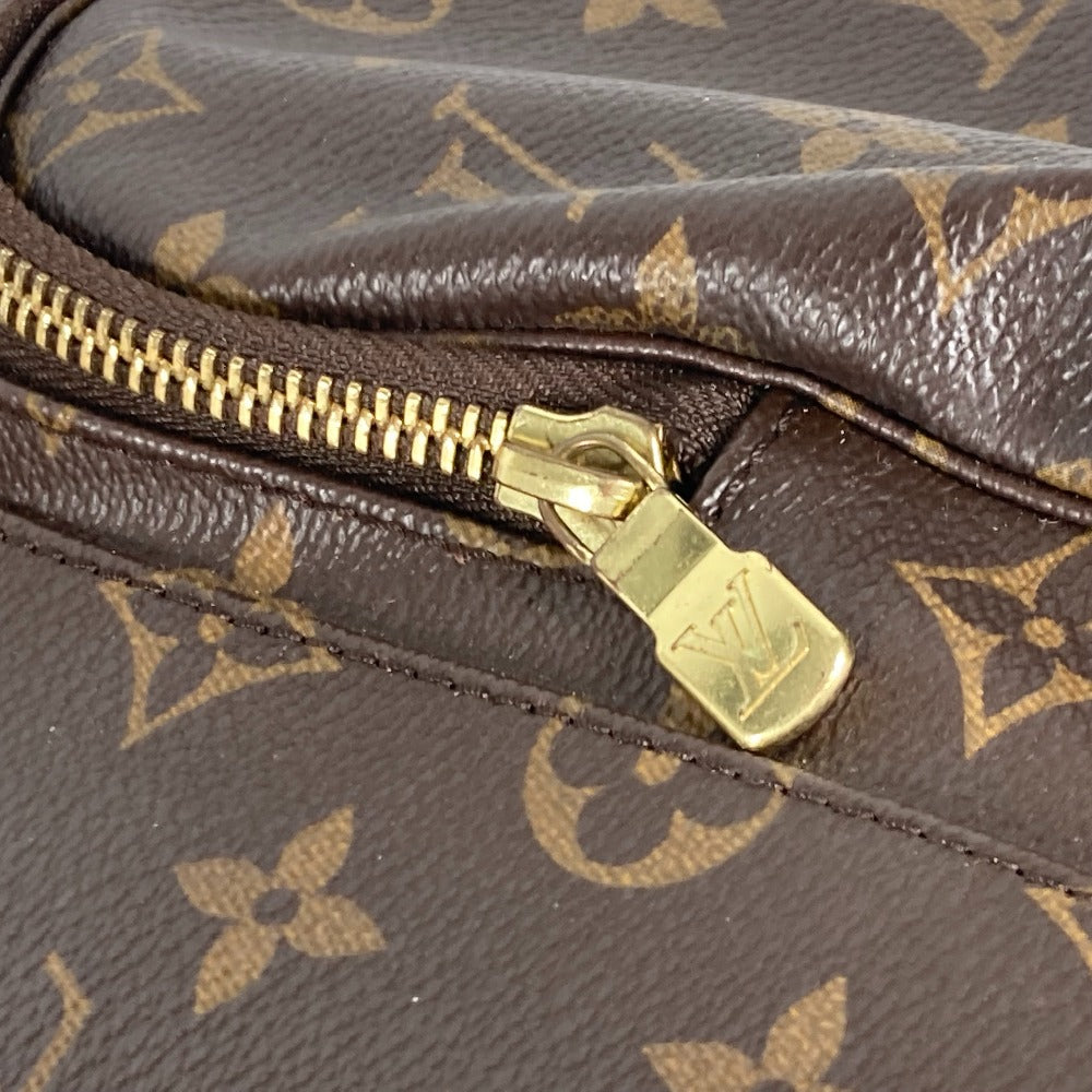 Close-up of a brown leather bag with gold zipper and monogram pattern