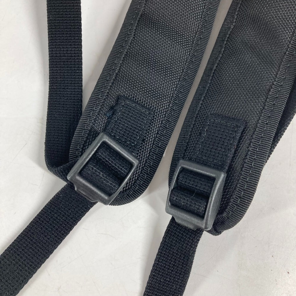 Black straps with buckles on a light gray background