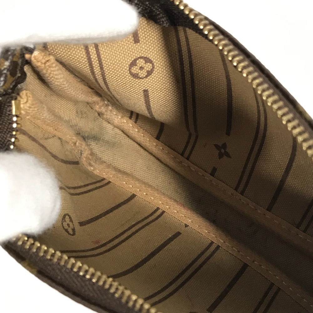 Close-up of a brown textured fabric with gold zipper and white fluffy material.
