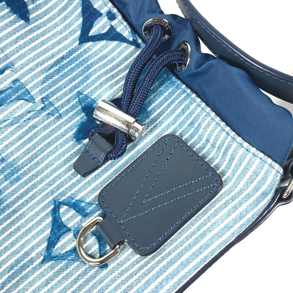 Close-up of a blue and white striped bag with a leather tag and metal buckle.
