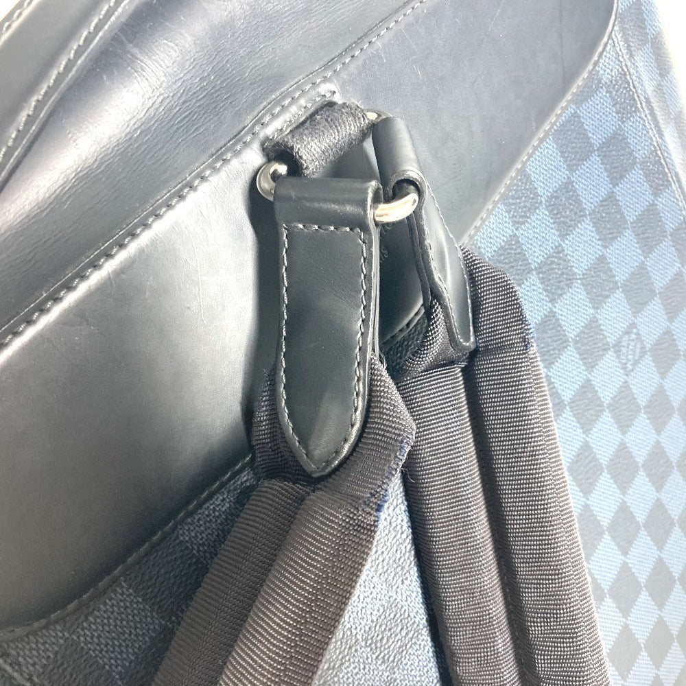 Close-up of a gray bag with a strap attachment on a textured surface.