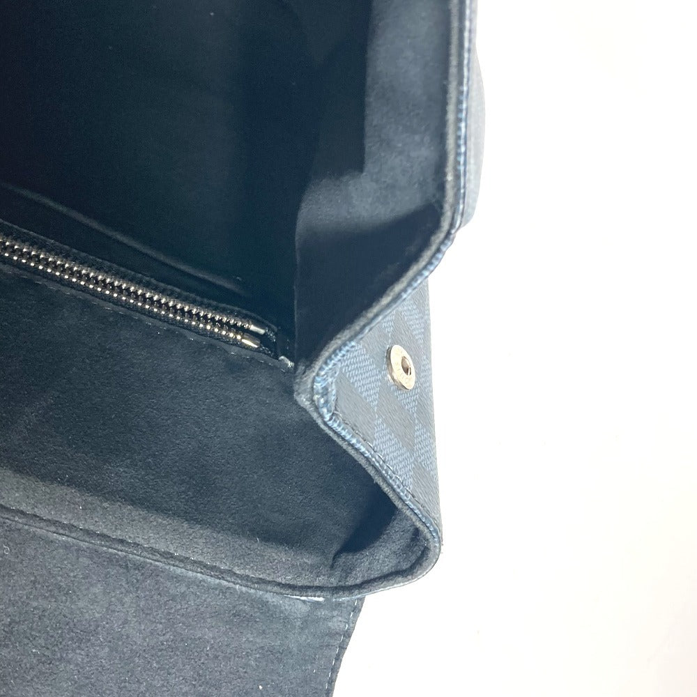 Close-up of a dark blue fabric bag with zipper and button detail on a white background
