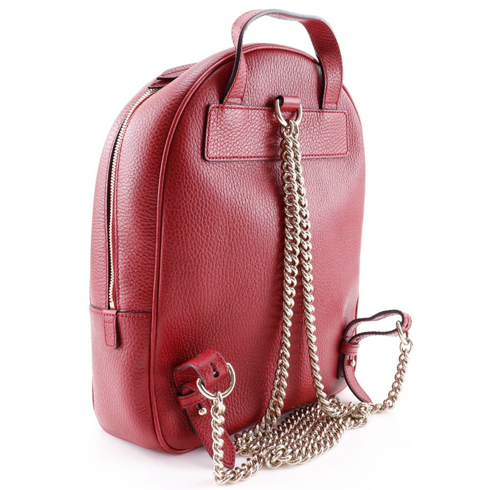 Red leather backpack with a chain detail on a white background