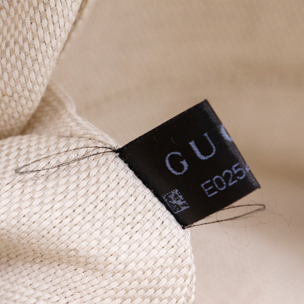 Close-up of a black label with 'GU' on a beige fabric background