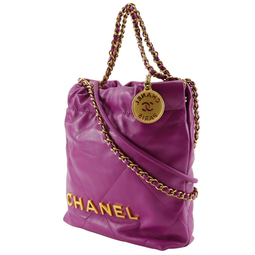 Purple Chanel handbag with gold chain and logo on a white background