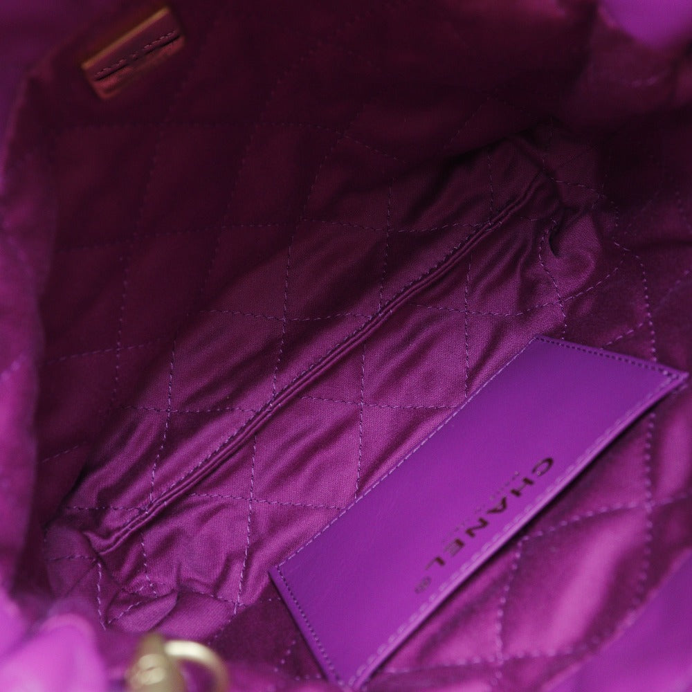 Close-up of a purple quilted bag with a visible brand label.
