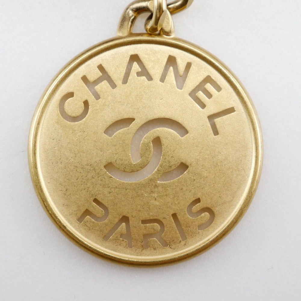 Gold Chanel pendant with 'Chanel Paris' on a white background