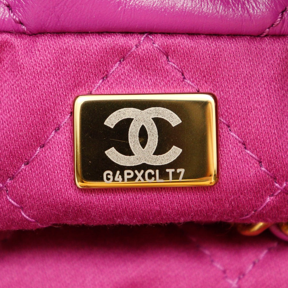 Close-up of a pink quilted handbag with a Chanel logo and serial number.