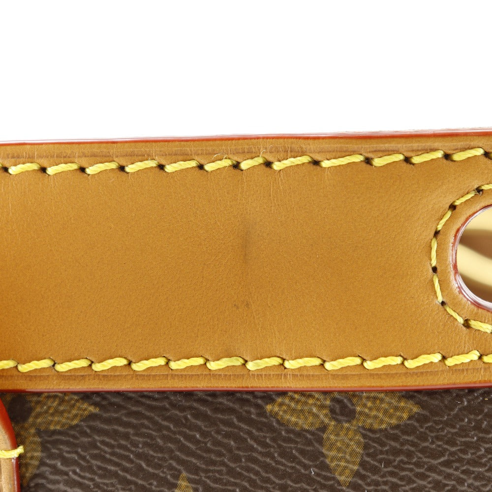Close-up of a brown leather product with yellow stitching on a white background