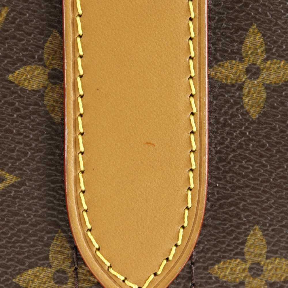 Close-up of a brown leather patch with gold stitching on a patterned background