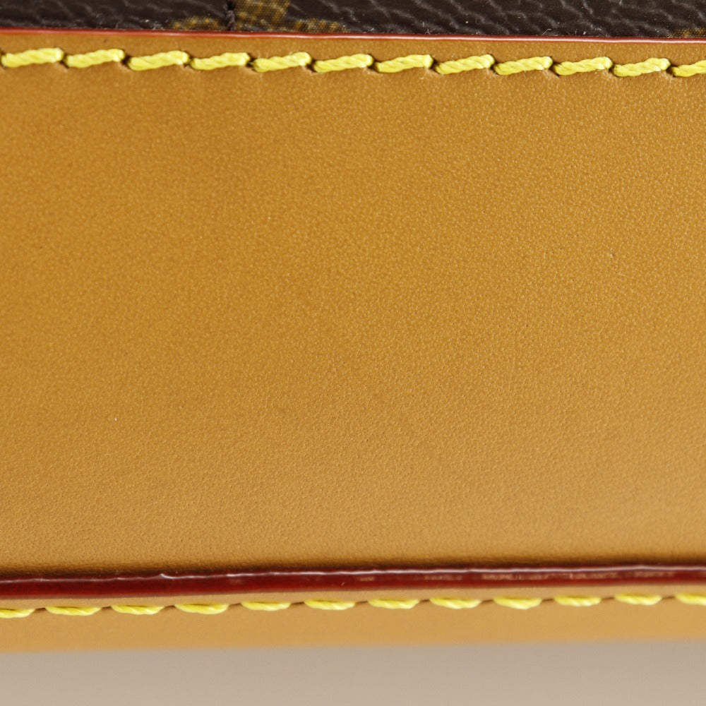 Close-up of a brown leather wallet with yellow stitching