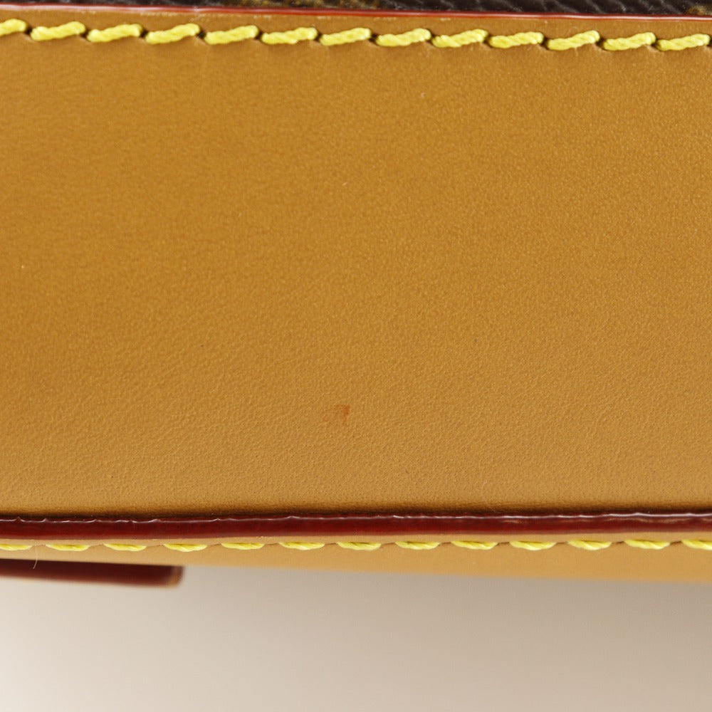 Close-up of a brown leather wallet with yellow stitching on a white background