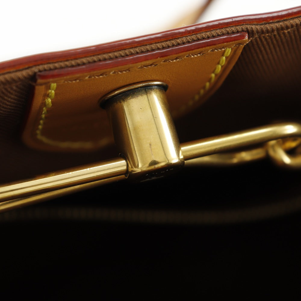 Close-up of a gold clasp on a brown leather bag