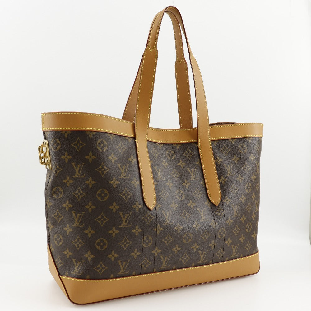 Designer handbag with monogram pattern and tan accents on a white background