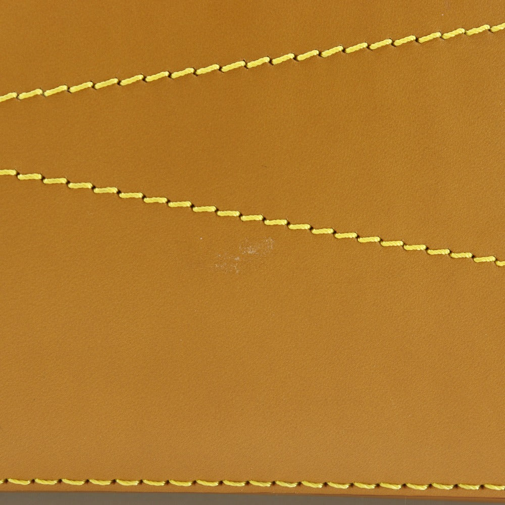 Close-up of brown leather with yellow stitching