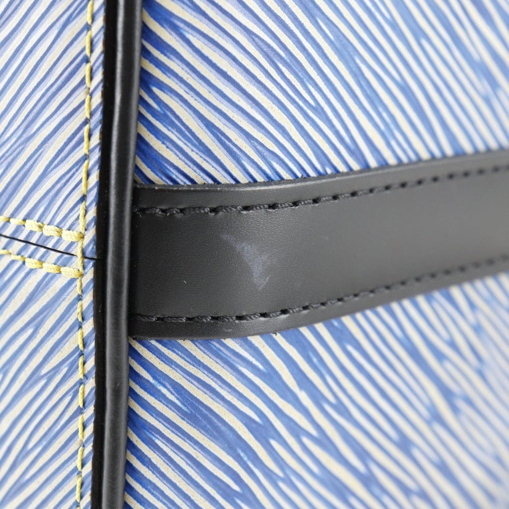 Close-up of a blue and white striped fabric with a black leather strap.