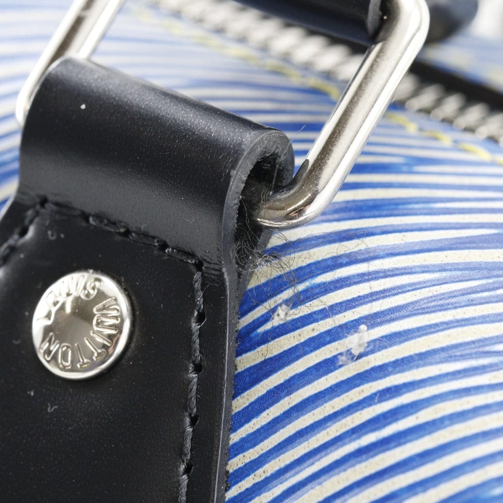 Close-up of a black leather strap with a metal buckle on a blue and white striped background.