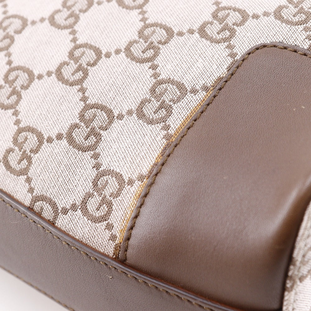Close-up of a brown handbag with a patterned design on a white background
