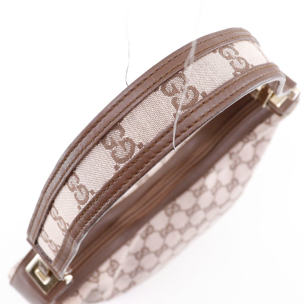 Brown handbag with a patterned strap on a white background