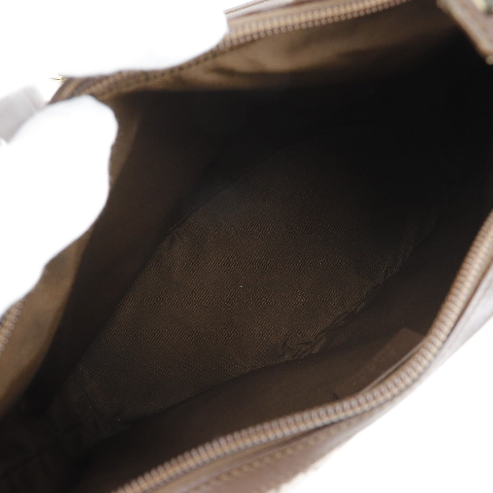Close-up of a brown leather bag with a zipper on a white background