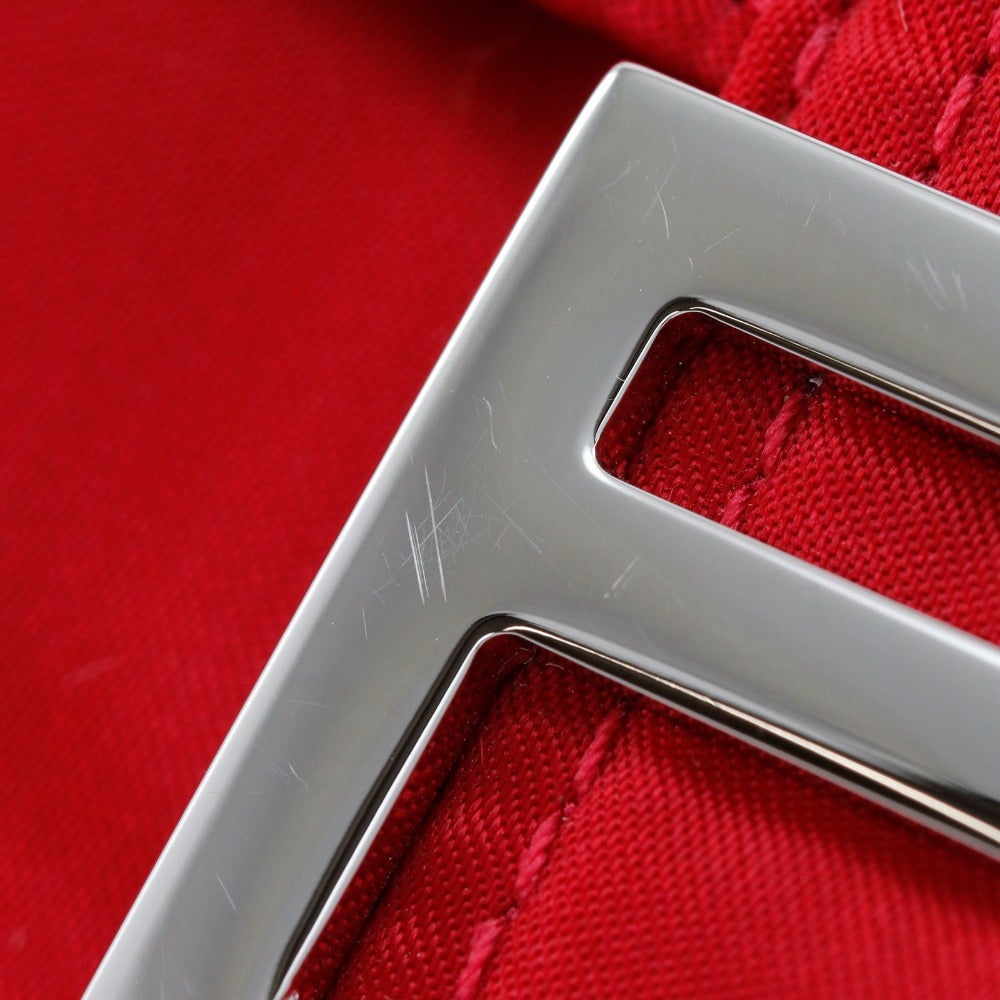 Metallic 'S' logo on a red textured background