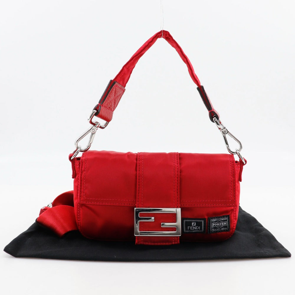 Red bag with a silver buckle on a black surface against a white background