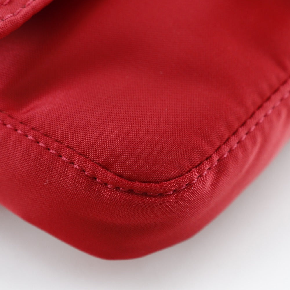 Close-up of a red fabric surface with stitching details on a white background