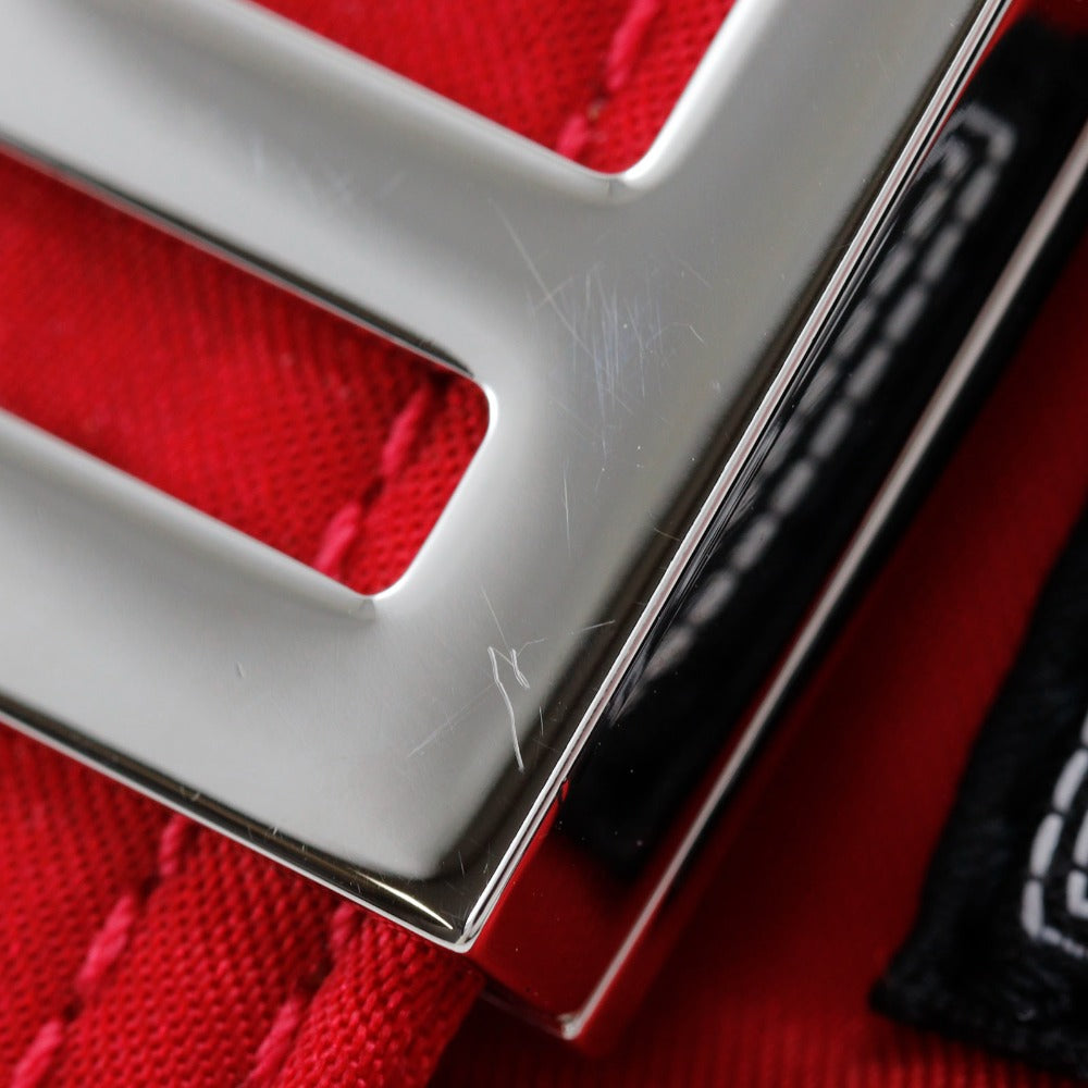 Close-up of a silver emblem on a red textured surface
