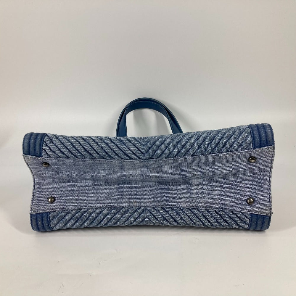 Blue denim handbag with a zigzag pattern on a white background