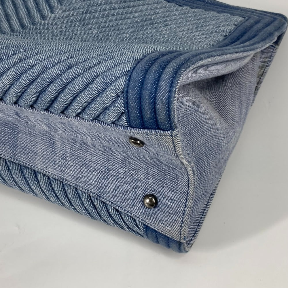 Close-up of a blue denim clutch bag on a light gray background