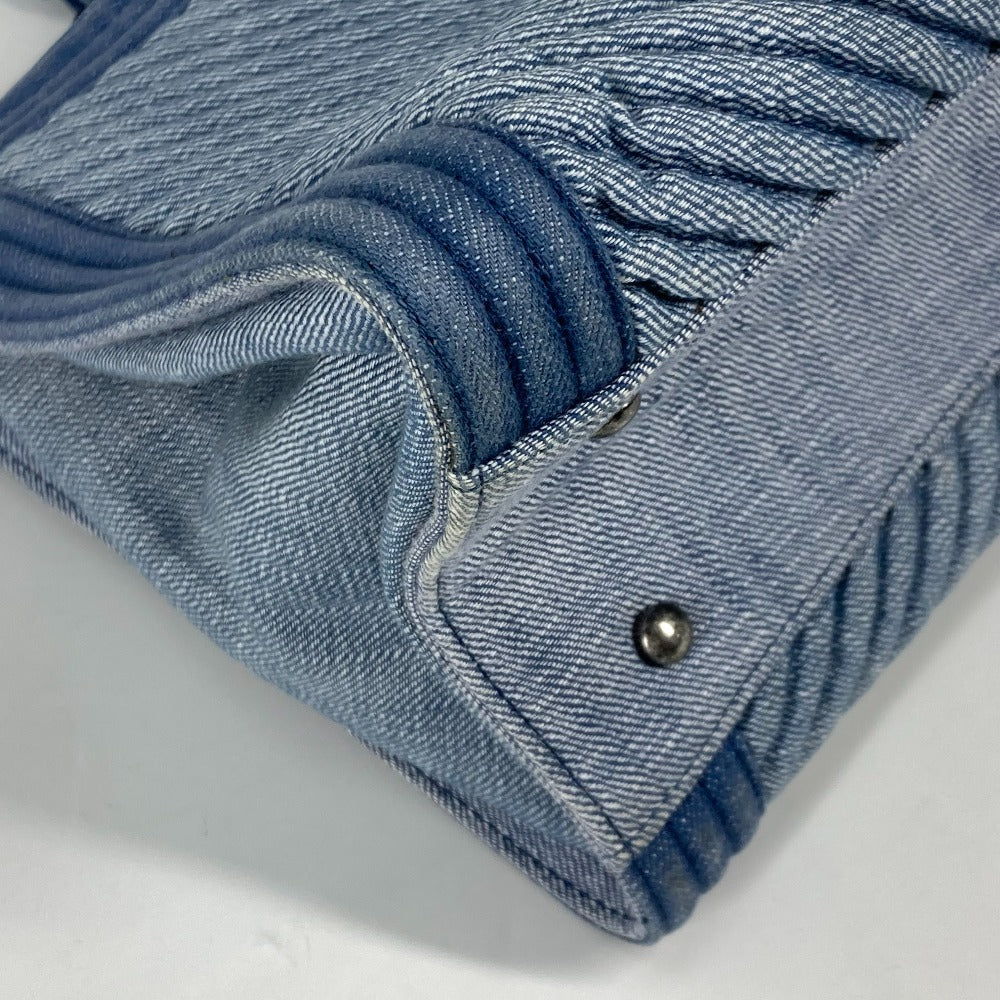 Close-up of a blue denim fabric with a button on a white background
