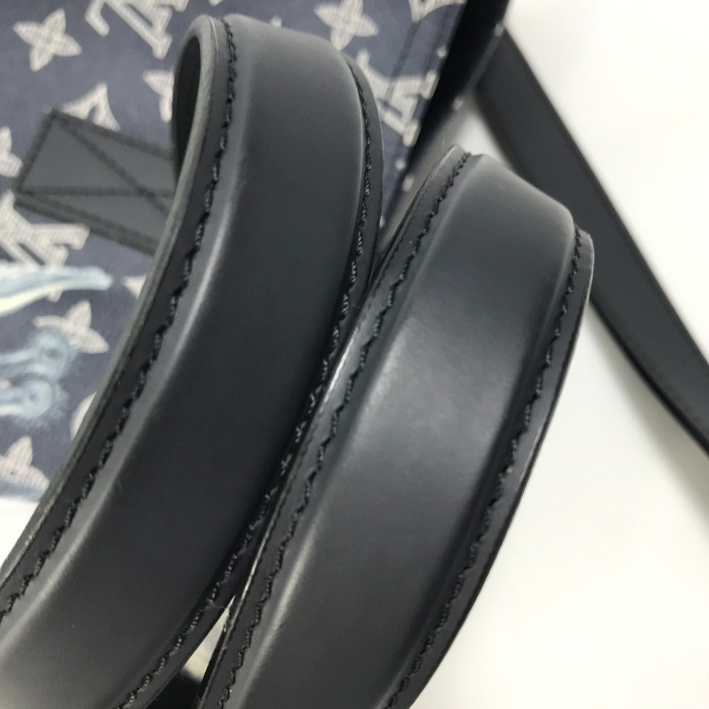 Close-up of a black leather belt with visible stitching on a patterned fabric background.