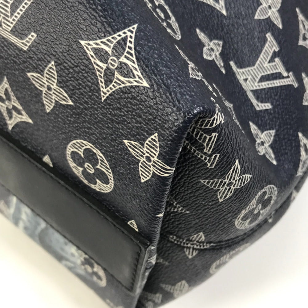 Close-up of a black handbag with white monogram pattern on a white background
