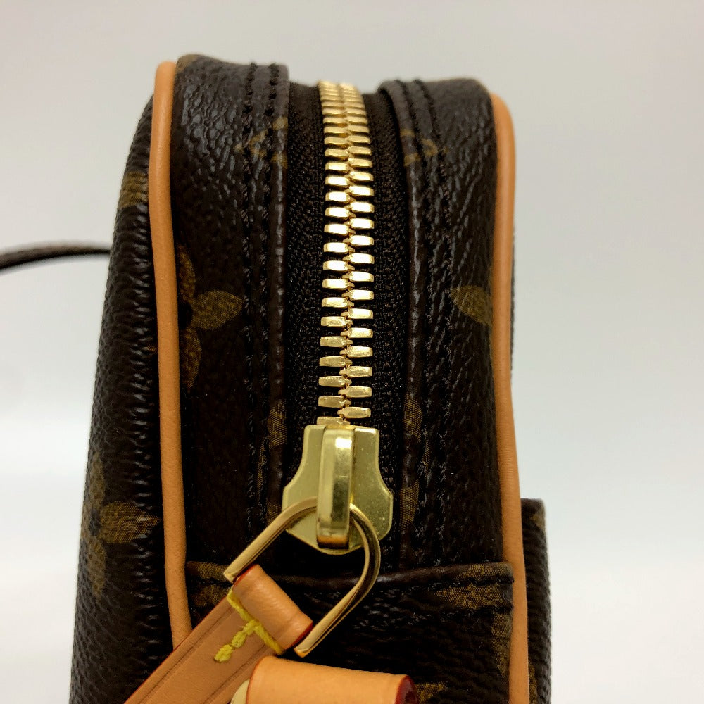 Close-up of a brown leather handbag with gold zipper and handle on a white background