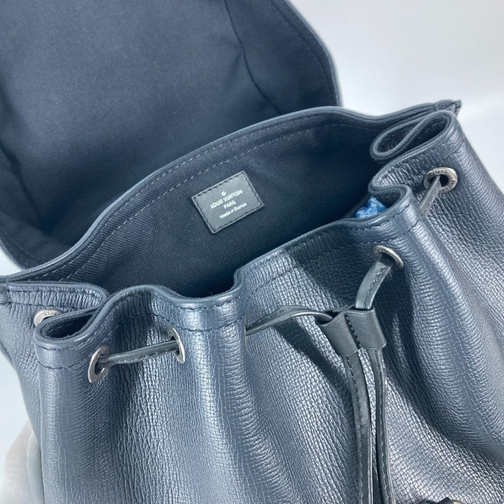 Close-up of a textured blue leather bag with a visible brand label.