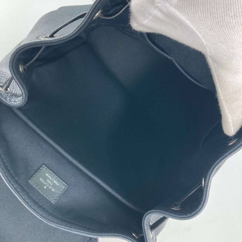 Blue leather bag with a white hat inside on a light gray background