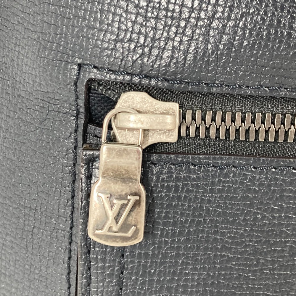 Close-up of a zipper on a black leather bag with a visible brand logo.