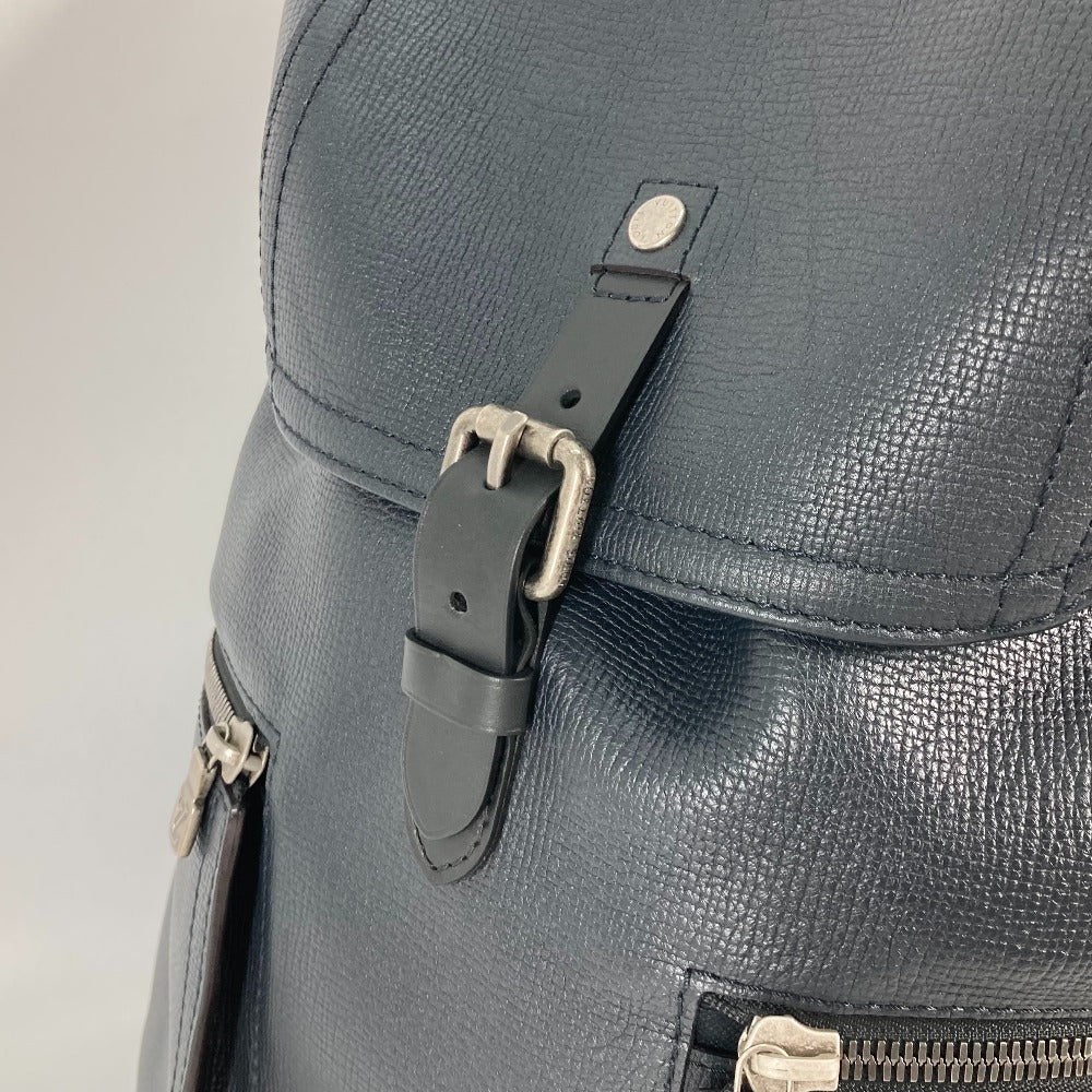 Close-up of a gray backpack with a leather strap and metal buckle on a light background