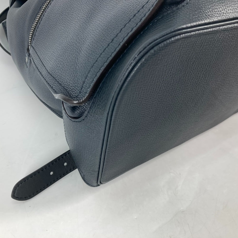 Close-up of a black leather bag with a strap on a light gray background