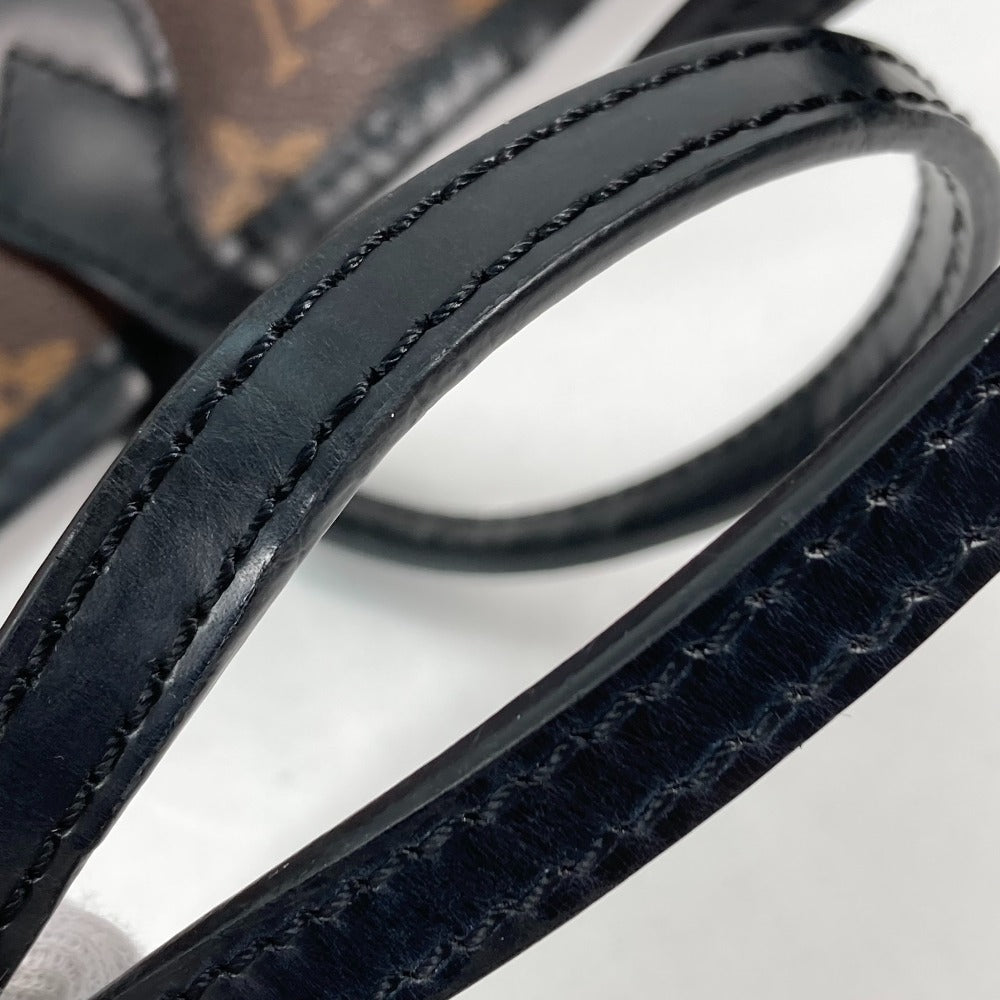 Close-up of a black leather belt with visible stitching on a light gray background