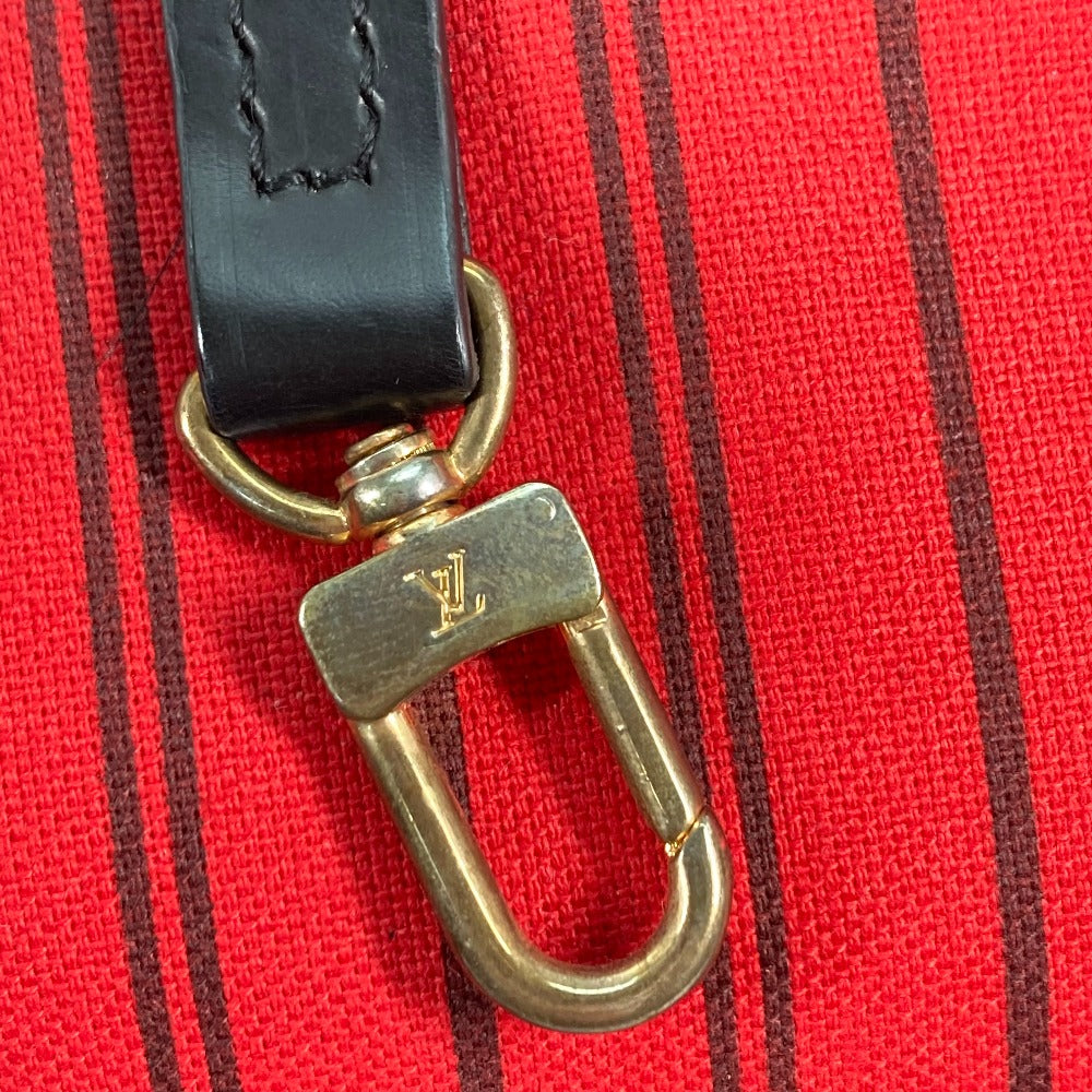 Gold hardware on a black strap against a red background