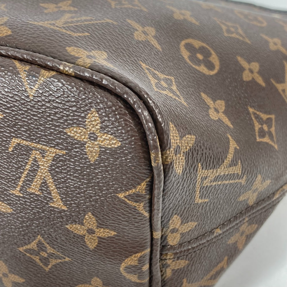Close-up of a brown leather bag with gold monogram pattern