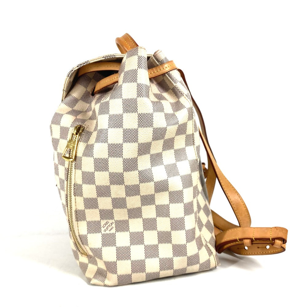Checkered backpack with brown leather straps on a white background