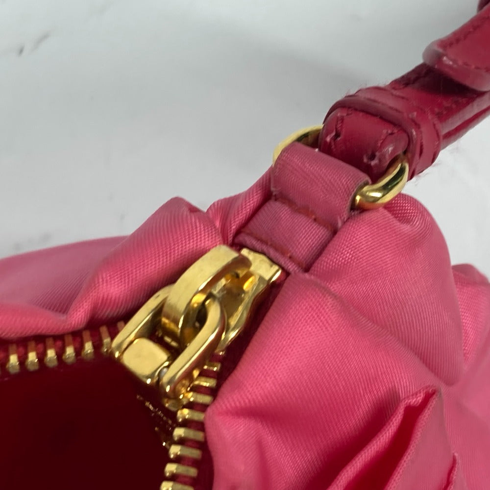 Close-up of a pink handbag with a gold zipper on a white background