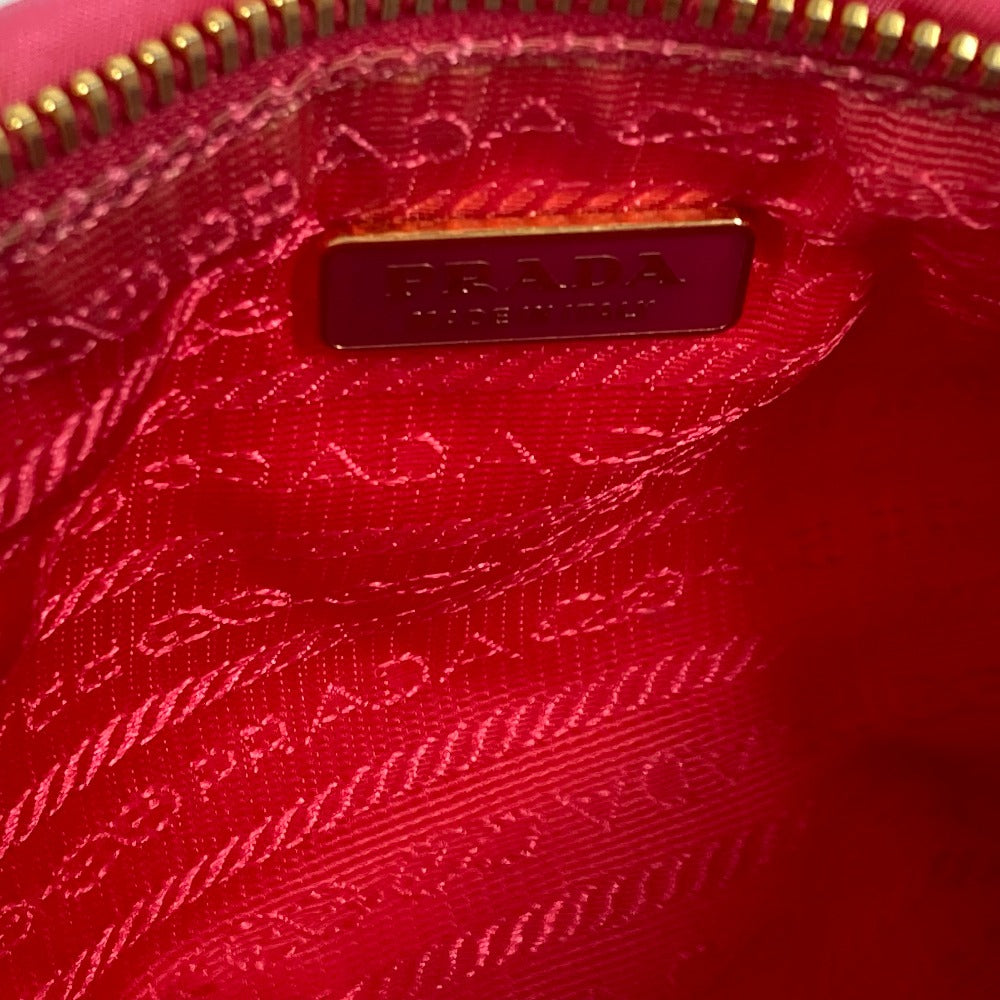 Close-up of a Prada handbag with a gold zipper and logo.