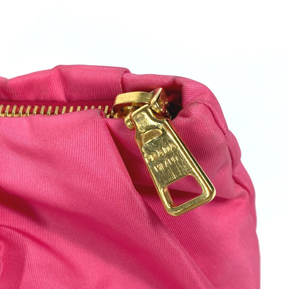 Close-up of a pink bag with a gold zipper pull on a white background