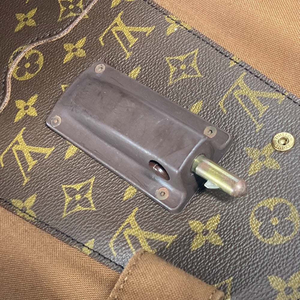 Close-up of a brown leather bag with gold monogram pattern and metal clasp.